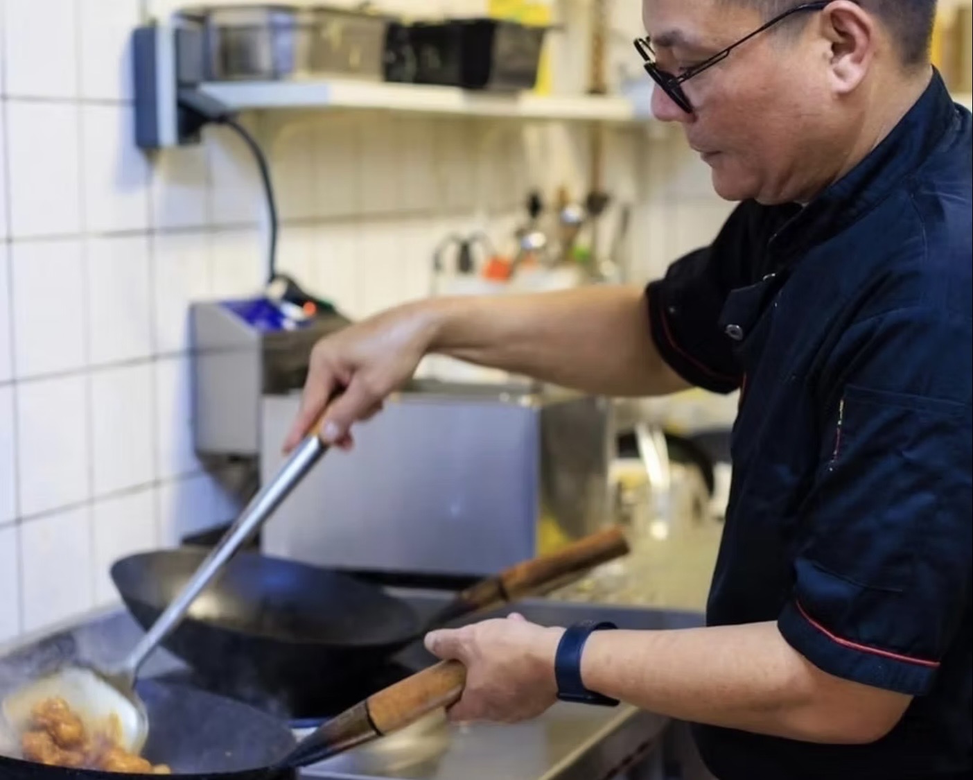 Onze chef aan de wok in de keuken van Berempah